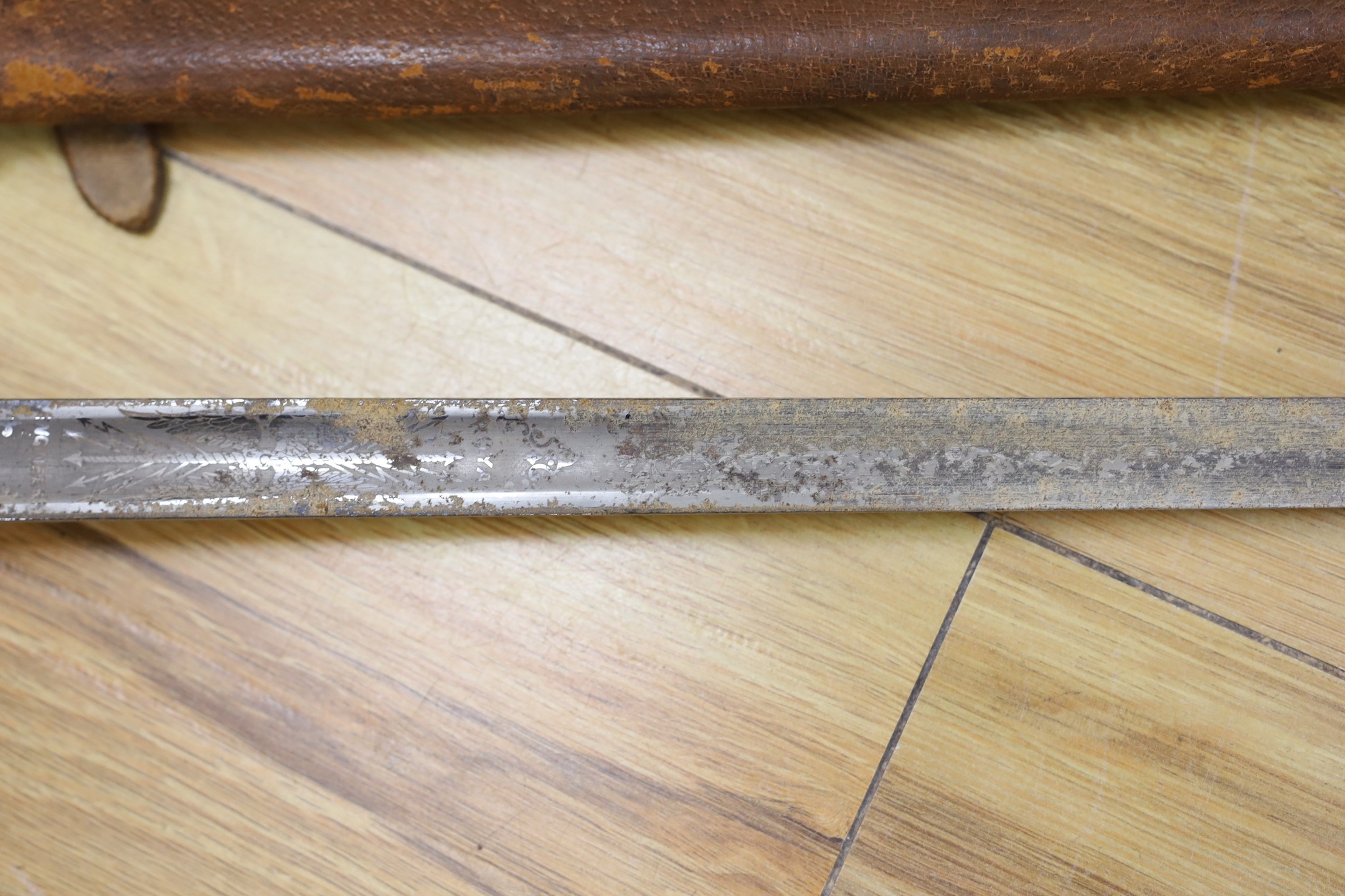 A George V military dress sword in brown leather covered scabbard, 102cm long, and a Middle Eastern dagger with carved and painted handle